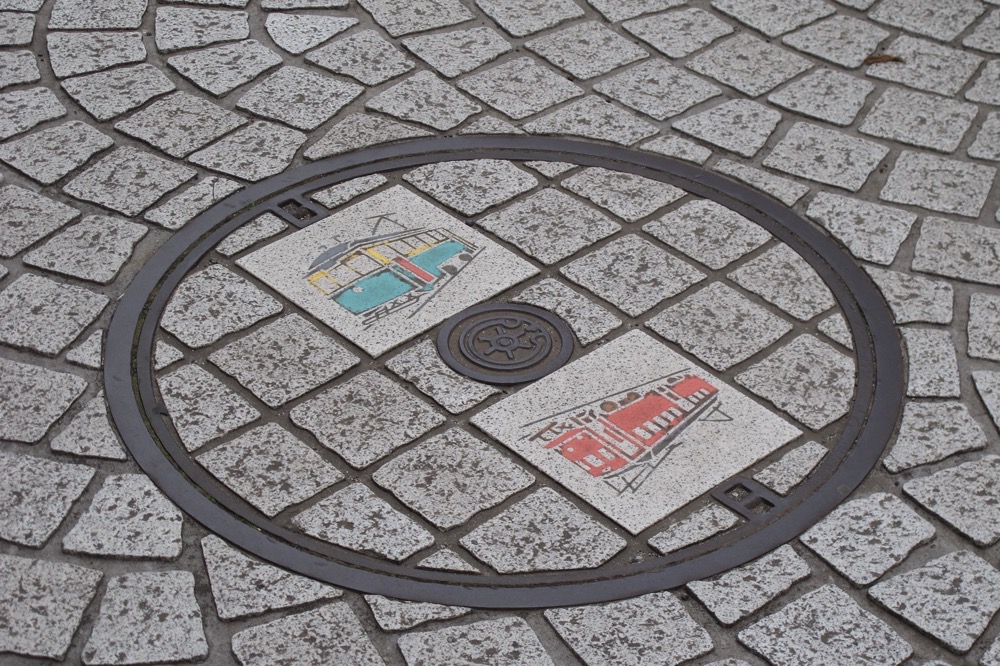 砧線と縁の深いデハ1・20形が描かれた砧線跡歩道上のマンホール／2013年3月3日 中耕地駅跡付近