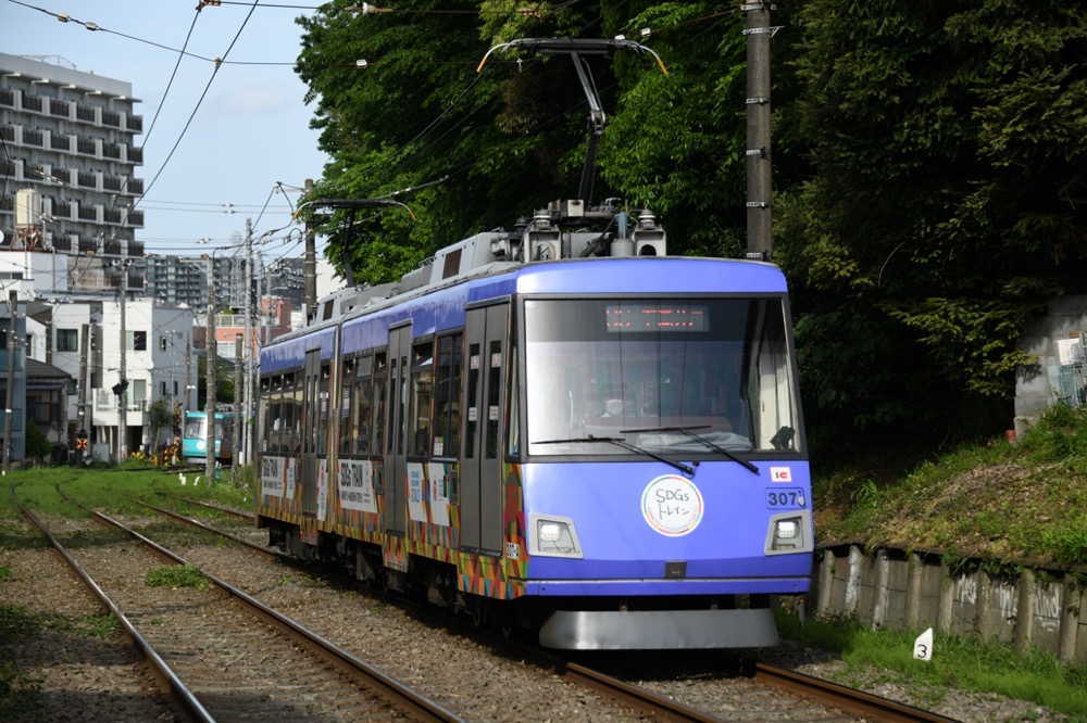 林の横を抜ける307編成「SDGsトレイン美しい時代へ号」／2023年4月29日 若林〜松陰神社前間